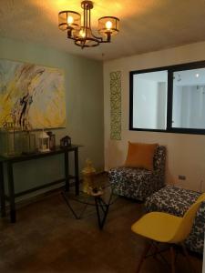 a living room with a couch and a chair at Hotel Boutique Valverde Santa Elena in San Salvador