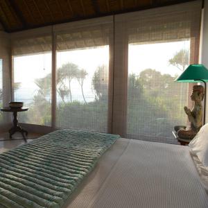レンボンガン島にあるVilla Bahagiaのベッドルーム(大型ベッド1台、大きな窓付)