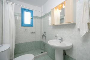Un baño blanco con lavabo e inodoro. en Mike's Studios, en Naxos Chora
