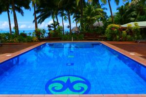 una piscina en un complejo con palmeras en Le Vasa Resort, en Fuailalo