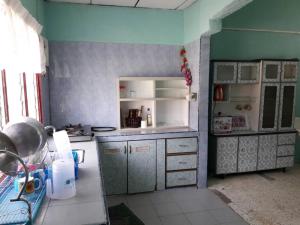 a kitchen with a counter and a refrigerator at Homestay Ustaz in Taiping