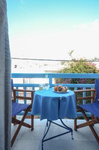 a table with a plate of food on a balcony with the beach at Mike's Studios in Naxos Chora