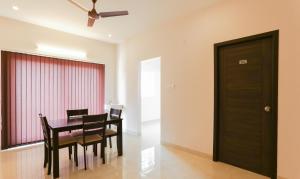 uma sala de jantar com uma mesa e cadeiras e uma ventoinha de tecto em Treebo Trend Hi Line Apartments Kalapatti em Coimbatore