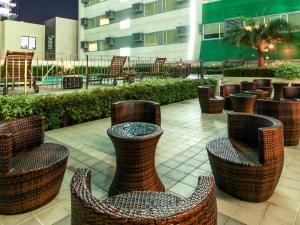 eine Gruppe von Stühlen und Tischen auf einer Terrasse in der Unterkunft Hotel 101 - Manila in Manila