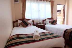 ein Zimmer mit 2 Betten und Handtüchern darauf in der Unterkunft Latisha House in Chiang Rai