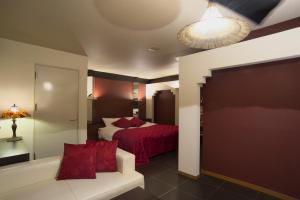 - une chambre avec un lit et un canapé dans l'établissement Hotel Coco-Palm (Love Hotel), à Tosu