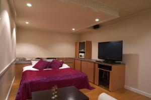 1 dormitorio con 1 cama y TV de pantalla plana en Hotel Coco-Palm (Love Hotel), en Tosu