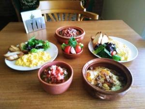 a table with plates of food and bowls of food at Domaine de Chouchene in Şaḩrat al Qashsh