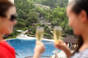a group of people drinking champagne in front of a pool at Pullman Zhangjiajie Hotel - Instagrammable in Zhangjiajie