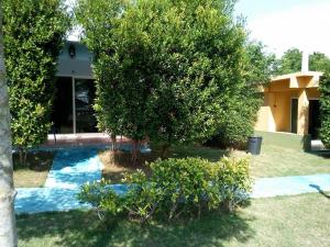 a house with a tree in front of a yard at AtMyHomeStay Bangsaphan in Bang Saphan