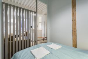 - une chambre avec un lit bleu et 2 serviettes dans l'établissement Jusquà 6 personnes au coeur du Vieux Lyon, à Lyon