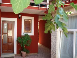 una casa roja con una puerta y una planta en Apartments Percan 447 en Krnica