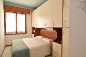 チェゼナーティコにあるStrand Lungomare Apartmentのベッドルーム1室(ベッド1台、白いキャビネット付)