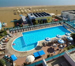 an overhead view of a swimming pool with chairs and umbrellas at Strand Lungomare Apartment in Cesenatico