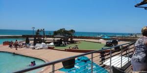 a group of people in a swimming pool next to the ocean at Humewood Home Stay in Port Elizabeth