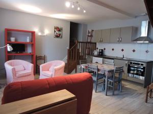 cocina y sala de estar con mesa y sillas en Les Pres Verts, en Mareuil-sur-Cher