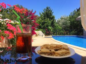 a drink and a plate of food on a table next to a pool at Dardanos Hotel in Patara