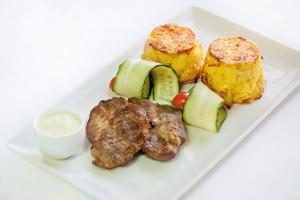 un plato de comida con patatas de carne y hortalizas en Kupecheskiy Club Hotel, en Bor