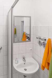 a white bathroom with a sink and a mirror at Apartment Wideystrasse in Witten