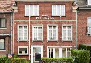 un edificio de ladrillo rojo con un hotel lleno en Full House Hotel en Kortrijk