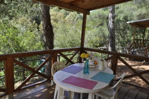 a table and chairs on the deck of a cabin at Elbadoc Camping Village in Cavo