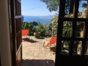 Une porte ouverte s'ouvre sur une terrasse offrant une vue sur l'océan. dans l'établissement Cottage Torre Elena - Staletti, à Stalettì