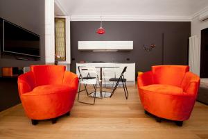 sala de estar con mesa y sillas de color naranja en Luxury Flat Riberi sotto la Mole, en Turín