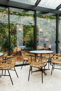 a patio with tables and chairs and windows at Maison Bréguet in Paris