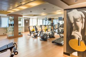 a gym with cardio equipment in a hotel room at Hotel Palafox in Zaragoza