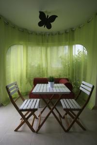 een tafel en twee stoelen en een vlinder aan de muur bij Ca Isaak in Denia