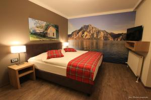 een slaapkamer met een bed en een schilderij van een berg bij Gasthof Alpenblick in Sierning