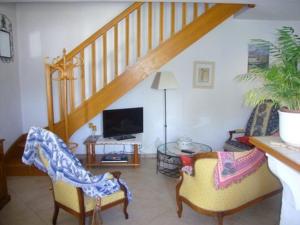 sala de estar con 2 sillas y escalera en Les Cigales, en Saint-Andiol