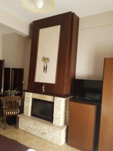 a living room with a fireplace and a television at Xenonas Arxontiko in Kato Loutraki