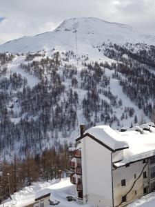 budynek w śniegu z górą w tle w obiekcie Monolocale Milky Way - Sestriere w mieście Sestriere