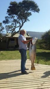 a man standing next to a fish statue at Breede River Holiday Farm Malgas in Malgas