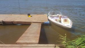 a boat is docked next to a wooden dock at Breede River Holiday Farm Malgas in Malgas