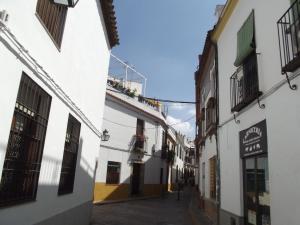 un callejón en una ciudad con edificios blancos en Casa Ruano en Córdoba