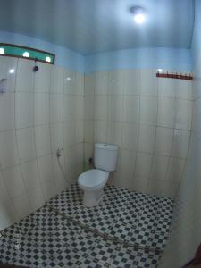 a bathroom with a toilet in a tiled room at Panorama Seulako in Sabong