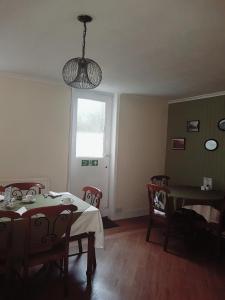 uma sala de jantar com uma mesa e cadeiras e uma janela em Castle House Guest House em Dover
