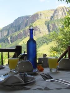 een tafel met een blauwe fles erop bij Forest Creek Lodge & Spa in Badfontein