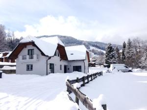 una casa cubierta de nieve con una valla en Kreischberg Holiday with Sauna, en Sankt Lorenzen ob Murau