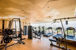 a gym with a lot of treadmills and ellipticals at Arize Hotel Sri Racha in Si Racha
