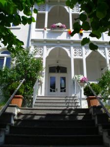 una casa blanca con escaleras y flores en la puerta en Apartments Haus Eintracht Sellin, en Ostseebad Sellin