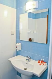 a bathroom with a white sink and a mirror at Hotel Astra in Sofia