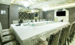a long table in a room with chairs and a television at Treebo Trend Hoops - Airport in Kolkata