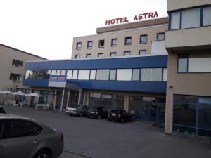 Ein Hotel in Asien mit auf einem Parkplatz geparkten Autos in der Unterkunft Hotel Astra in Sofia