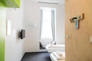 a room with two white beds and a mirror at Maverick Budapest Soho in Budapest