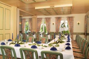 a conference room with a long table with blue and green chairs at Hotel & Gasthof Zum Löwen in Eisenach