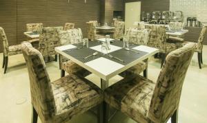 a dining room with a white table and chairs at Treebo Trend Hoops - Airport in Kolkata