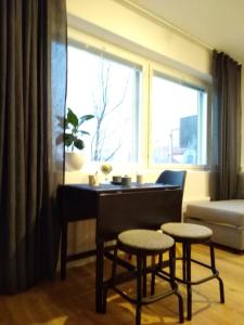 a living room with a piano and two stools in front of a window at Studiohuoneisto Lohjan keskusta in Lohja